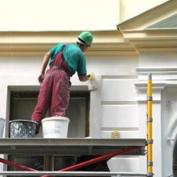 Man painting the outside of a building