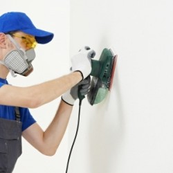 Man in mask removing lead paint
